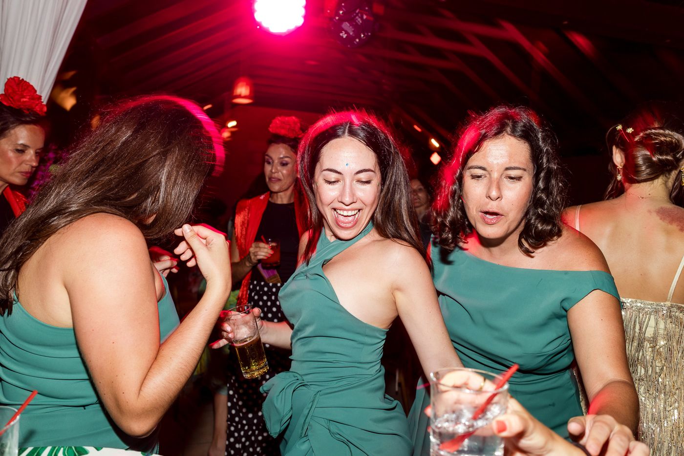 Wedding reception dance party with guests in green dresses enjoying the celebration.