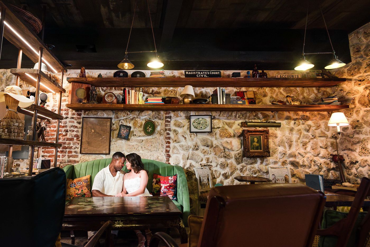 A couple shares an intimate moment at a rustic restaurant with exposed brick walls.