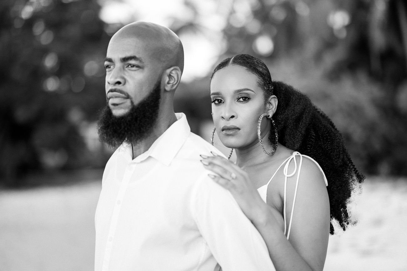 Artistic black and white portrait of couple in elegant attire.