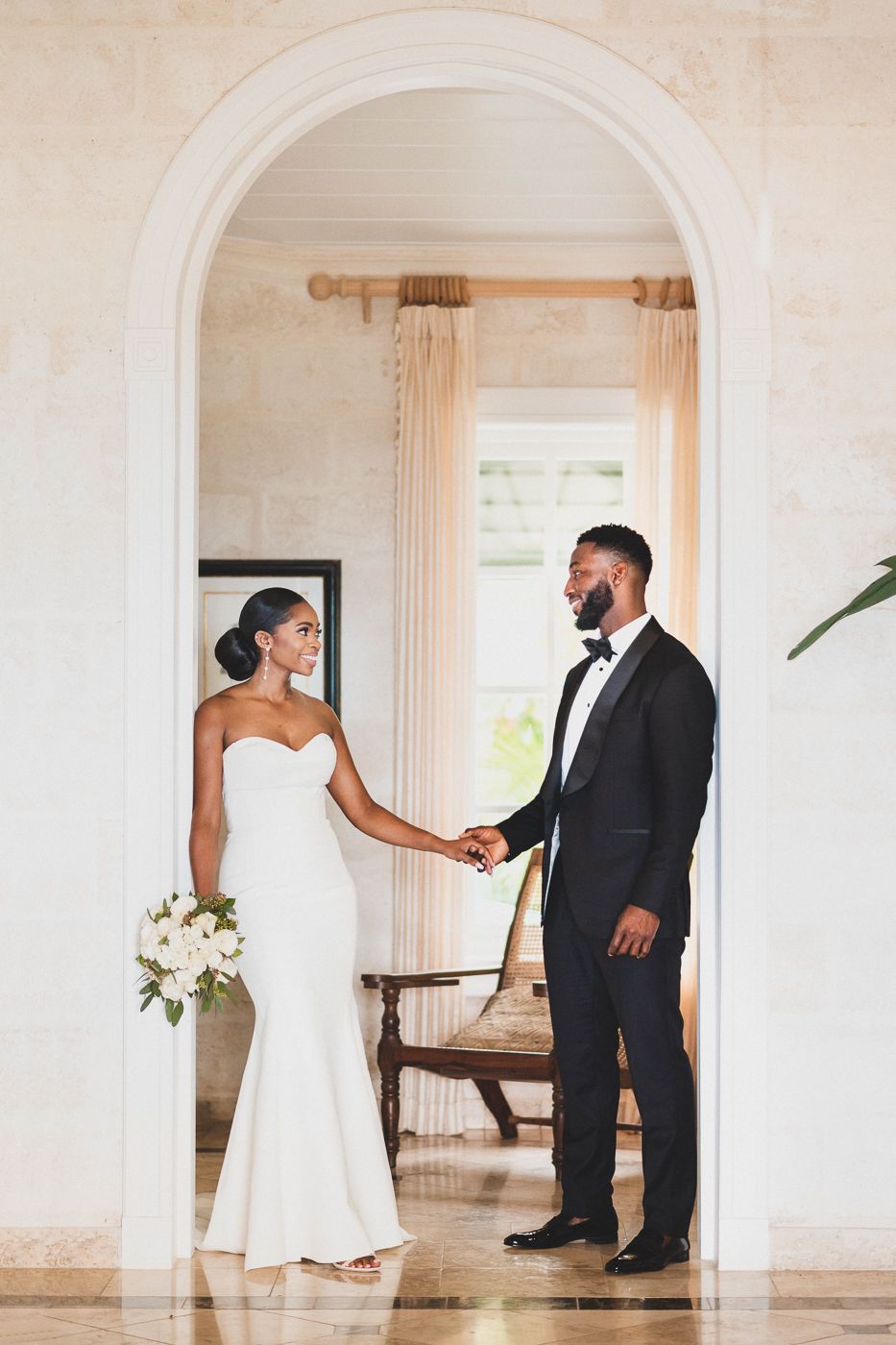 In a bright elegant room, bride and groom share their first look at Sandy Lane barbados, black luxury wedding photographers Celeste & Reece