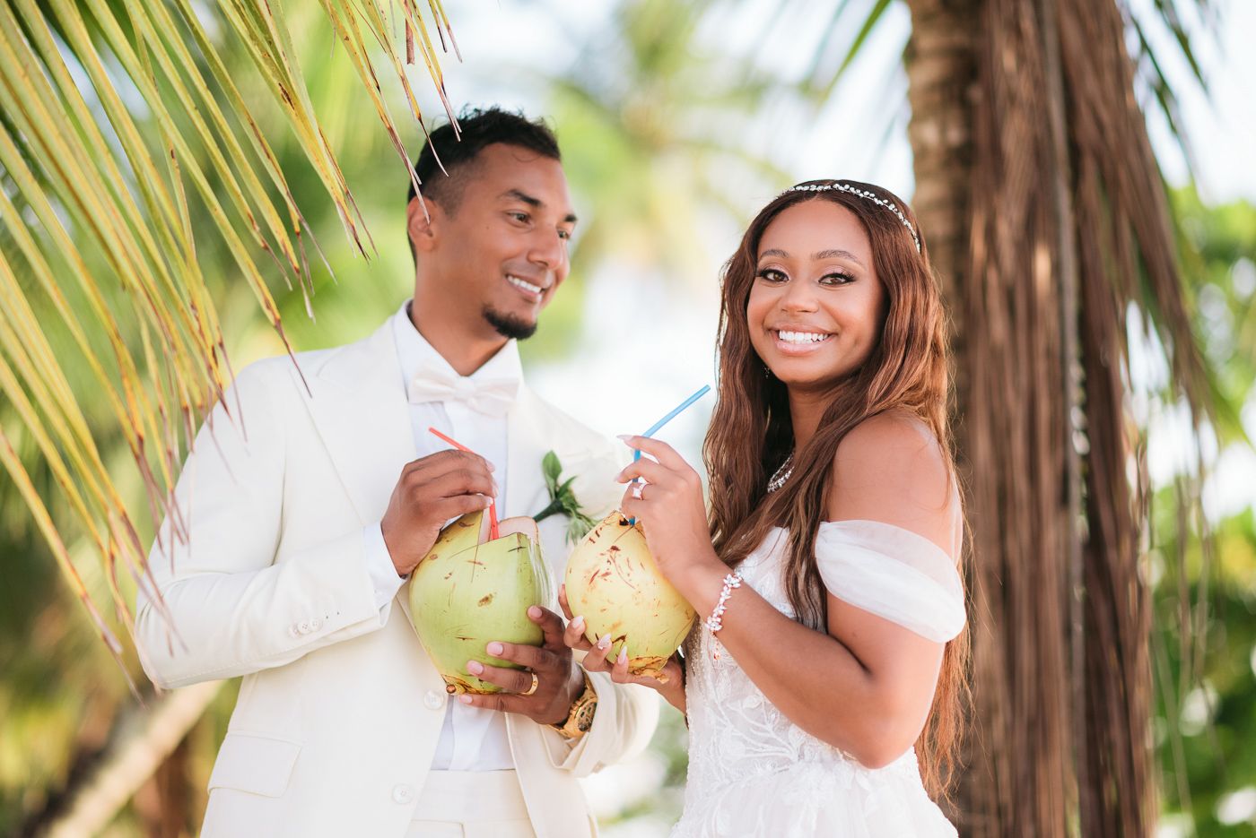Outdoor wedding portraits under palm trees with natural lighting.