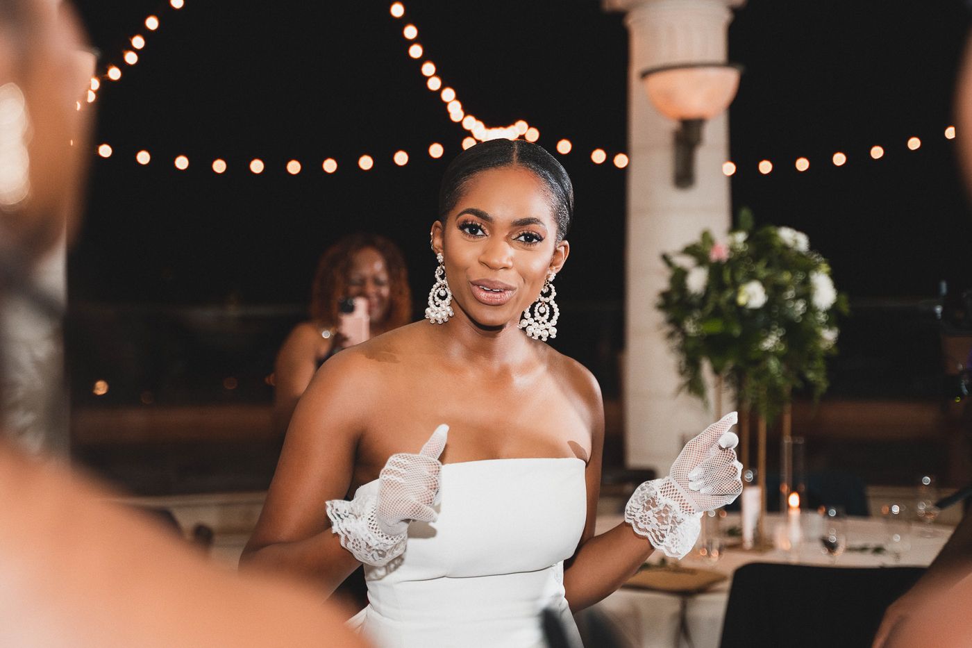 Stylish wedding reception set up with string lights and elegant white decor.