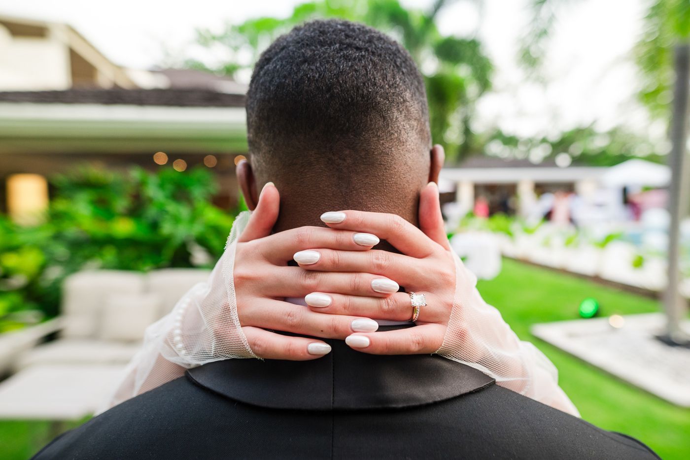 Close-up detail shot of hands during intimate wedding moment outdoors.