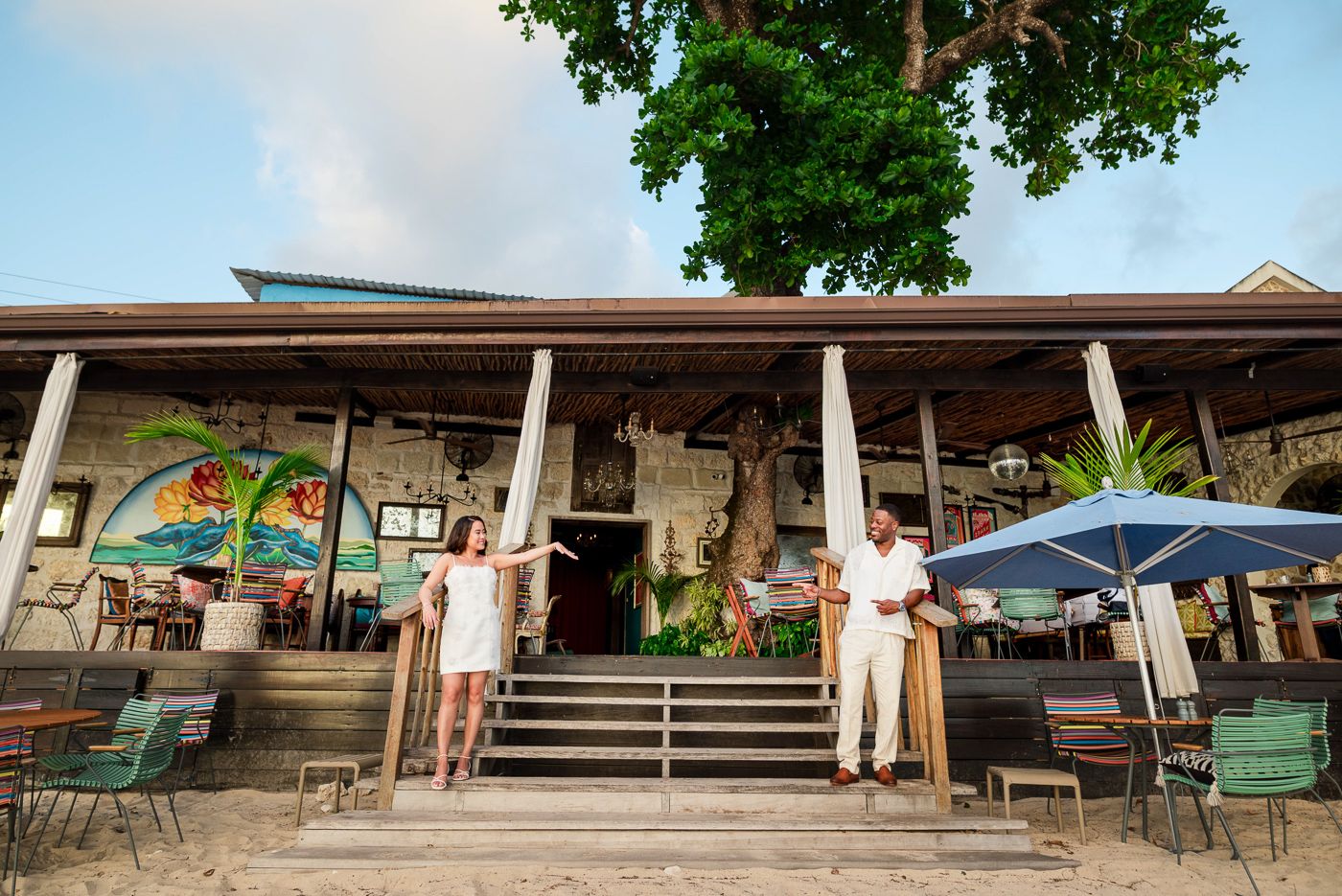 A charming beachside restaurant exterior with covered porch and tropical decor.