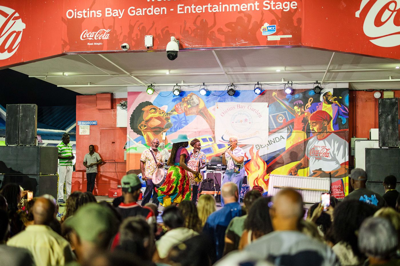 Crowd enjoying entertainment at Coca-Cola stage during outdoor festival.