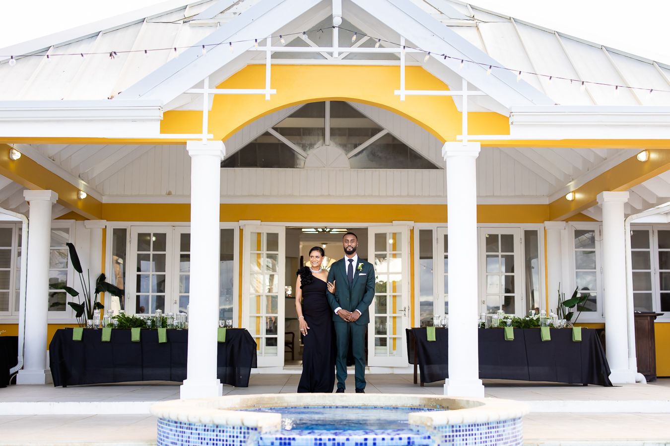 Yellow and white wedding pavilion with elegant columns and string lights for reception.