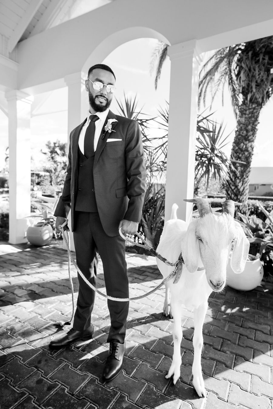 Black and white portrait series showing a bridal couple in formal attire on an elegant covered porch.