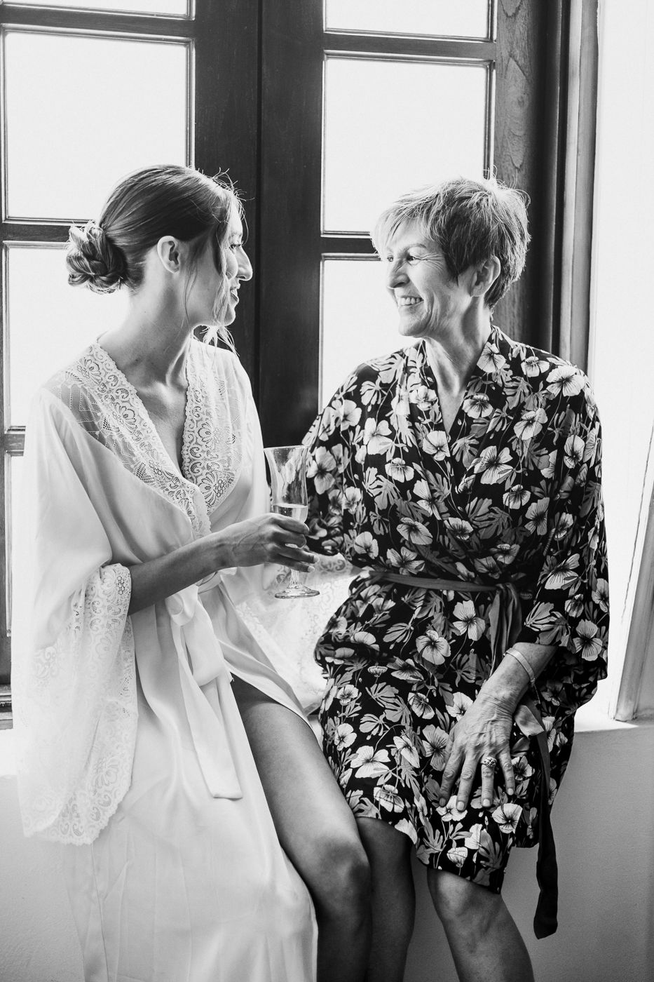 Two people dancing and laughing in black and white photo.