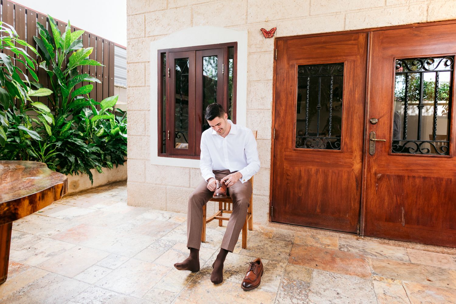 A series of exterior photos showing wooden doors, stone walls, and tropical landscaping at a luxury Spanish-style villa.