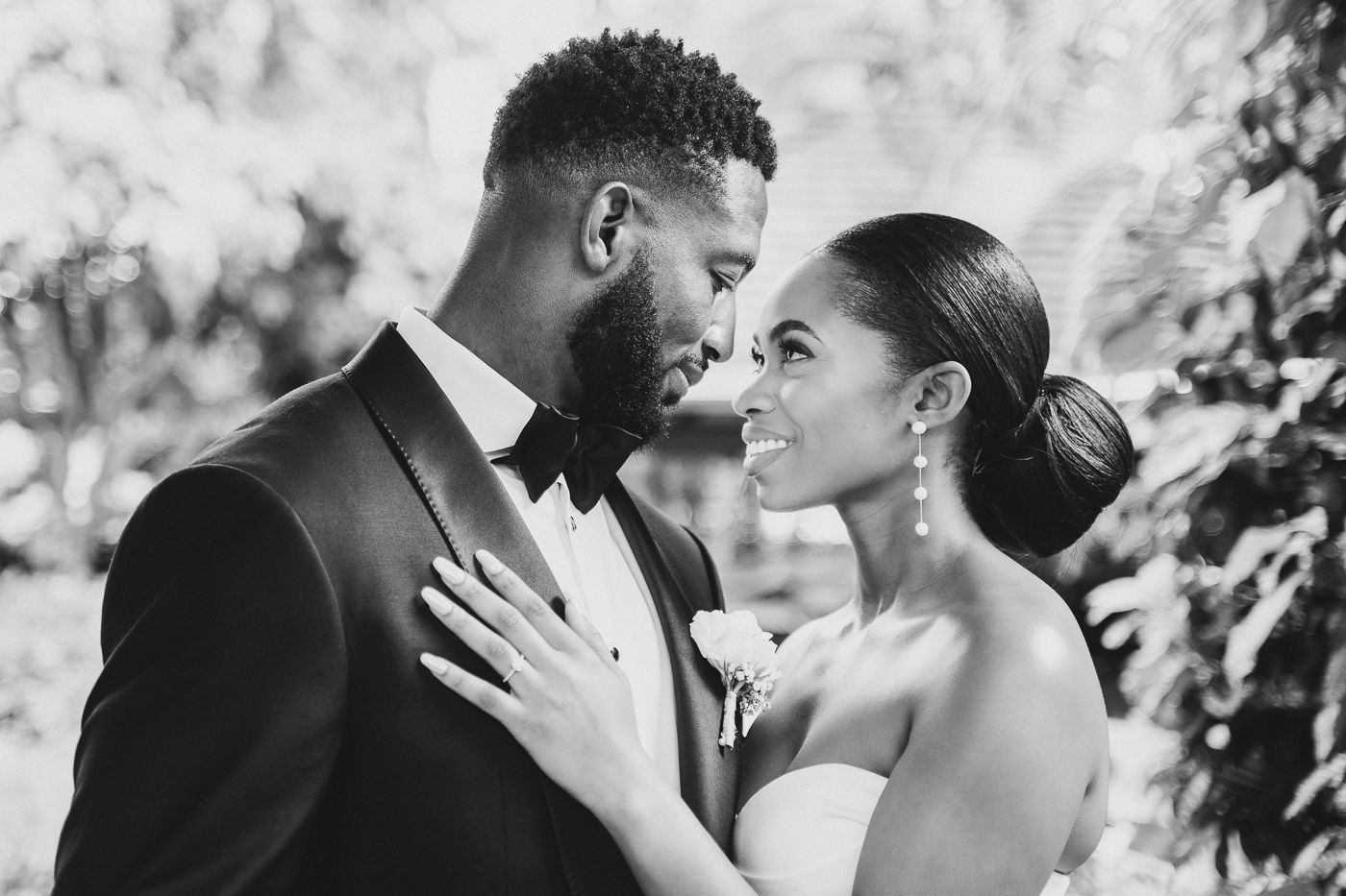 An intimate black and white portrait of newlyweds sharing a tender moment.