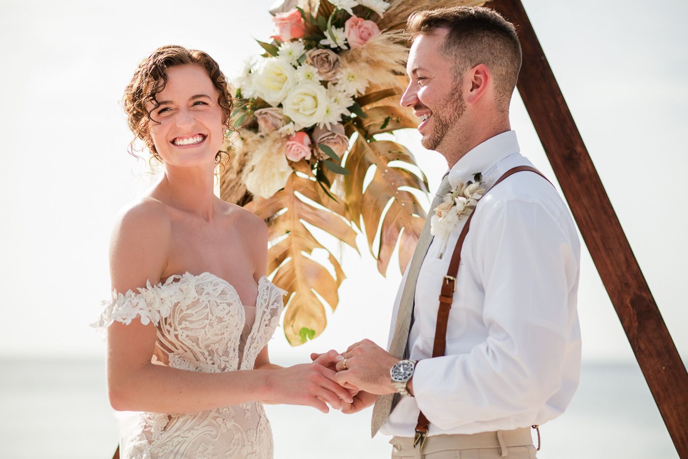 Happy couple sharing intimate moments during their beach wedding ceremony.