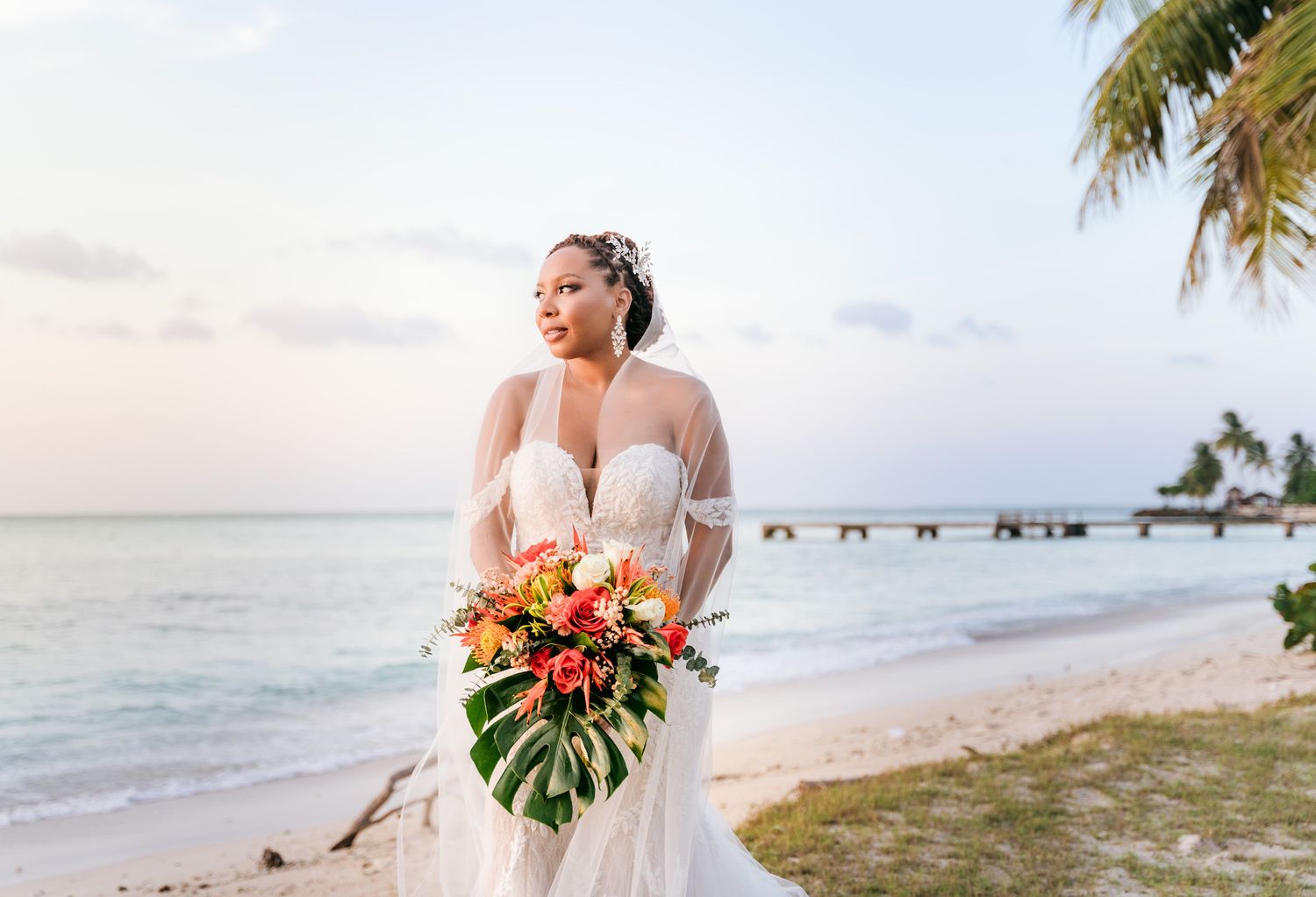 Tropical beach wedding ceremony setup with palm trees and ocean views.