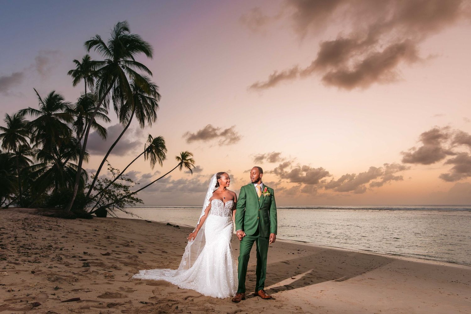 Panoramic beach wedding photoshoot at sunset with palm trees and ocean views.