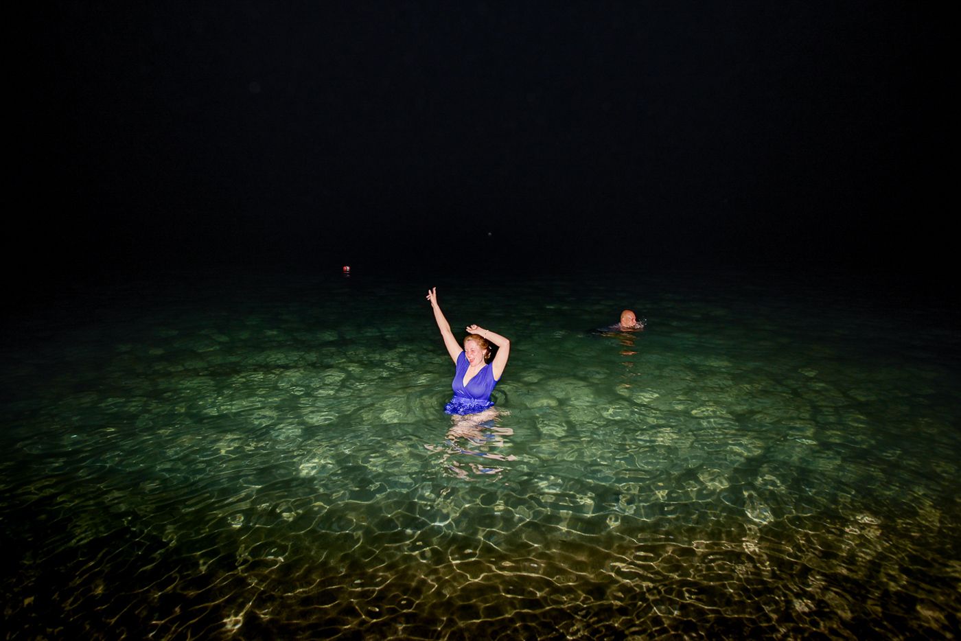 Night swimming celebration in crystal clear tropical waters.