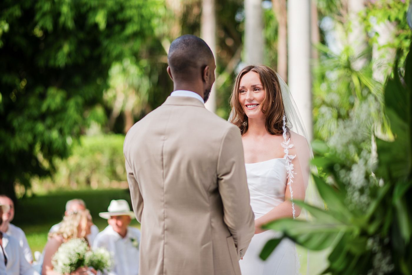 Intimate wedding ceremony moment captured in a lush tropical garden setting.