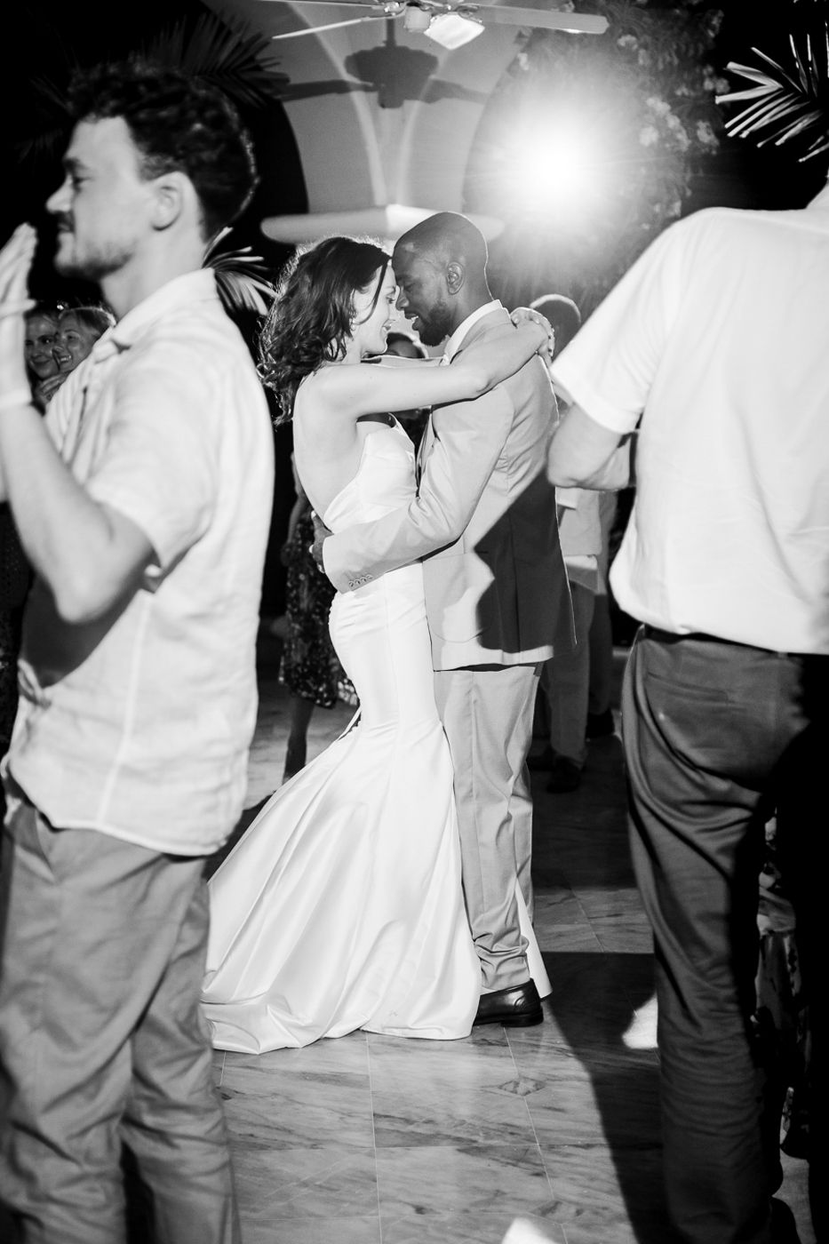 Black and white photo of couples slow dancing at an evening reception.