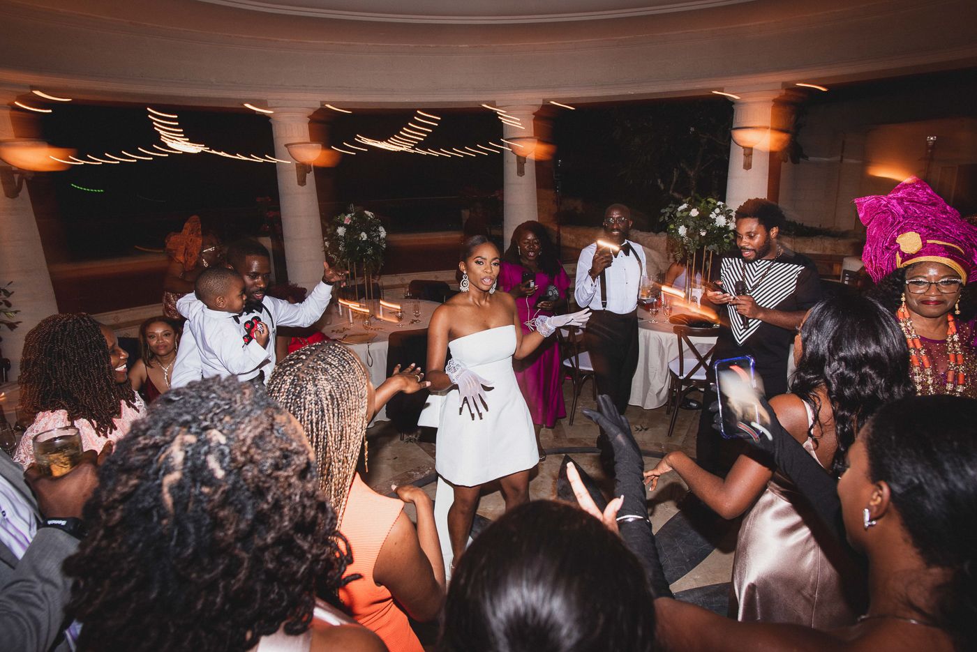 Lively dance party at a wedding reception with guests enjoying themselves on the dance floor.
