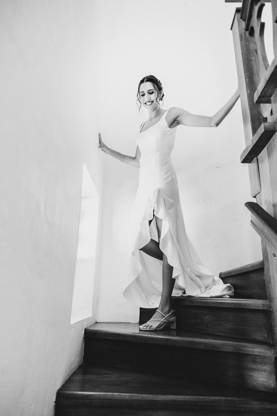 Artistic black and white photos capturing someone descending a staircase in a wedding dress.