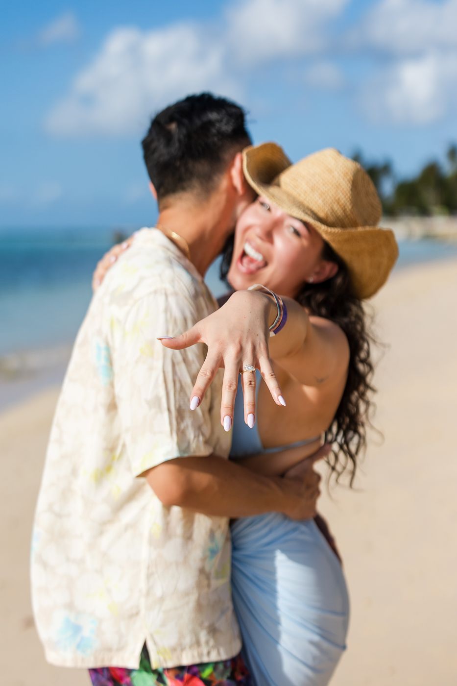 Loving embrace captured during beach photoshoot with turquoise waters and blue skies.