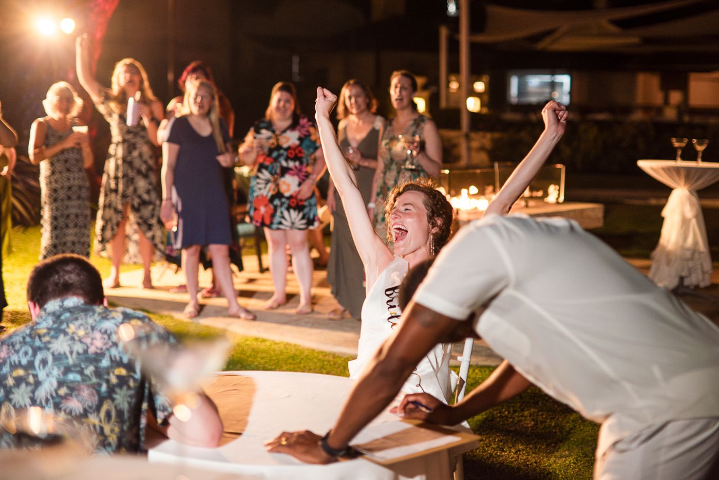 Celebratory moment at an outdoor party with people cheering and jumping in excitement.