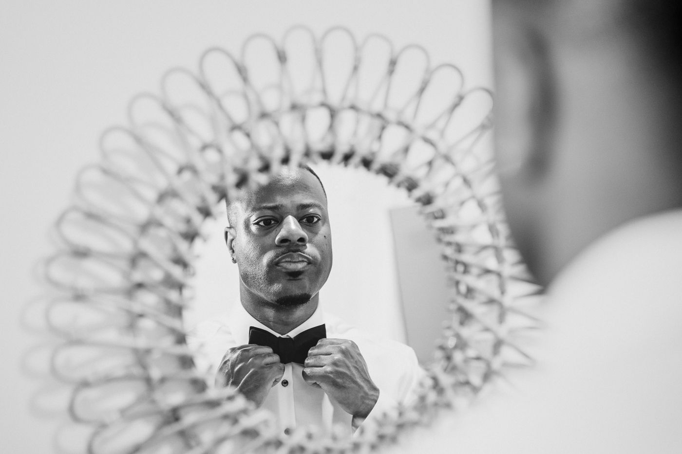 Black and white portrait with decorative circular pattern in background.