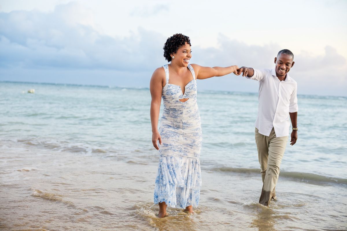 Happy couple shares romantic moments on a tropical beach during sunset photo session.