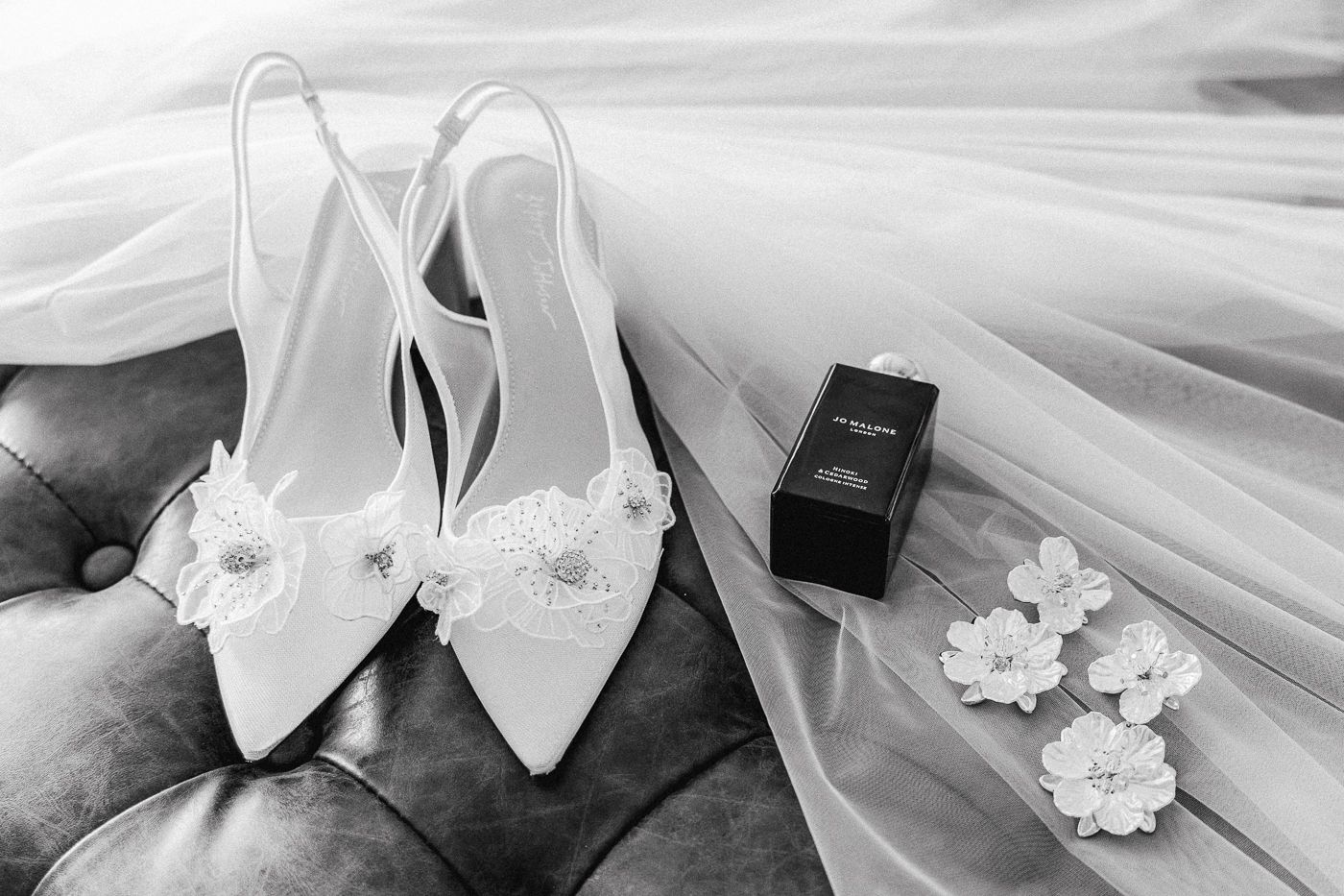 Black and white wedding detail photos showing rings, flowers, and bow ties arranged in an elegant collage.