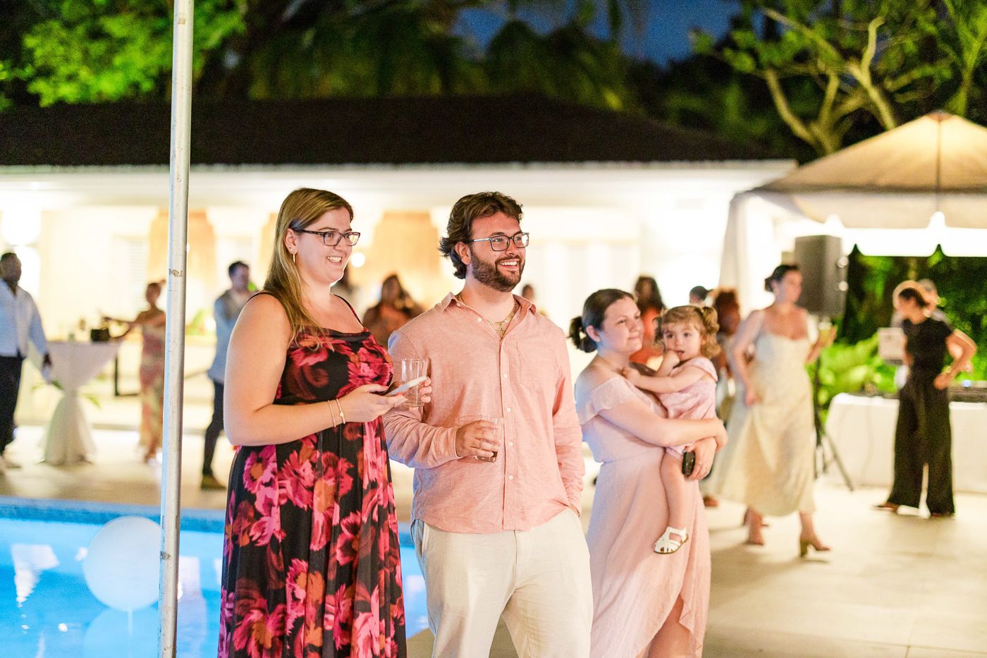Wedding reception celebration with guests dancing under covered outdoor space.