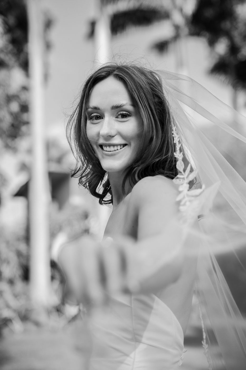 Black and white portraits showing joyful bridal moments with flowing veil.