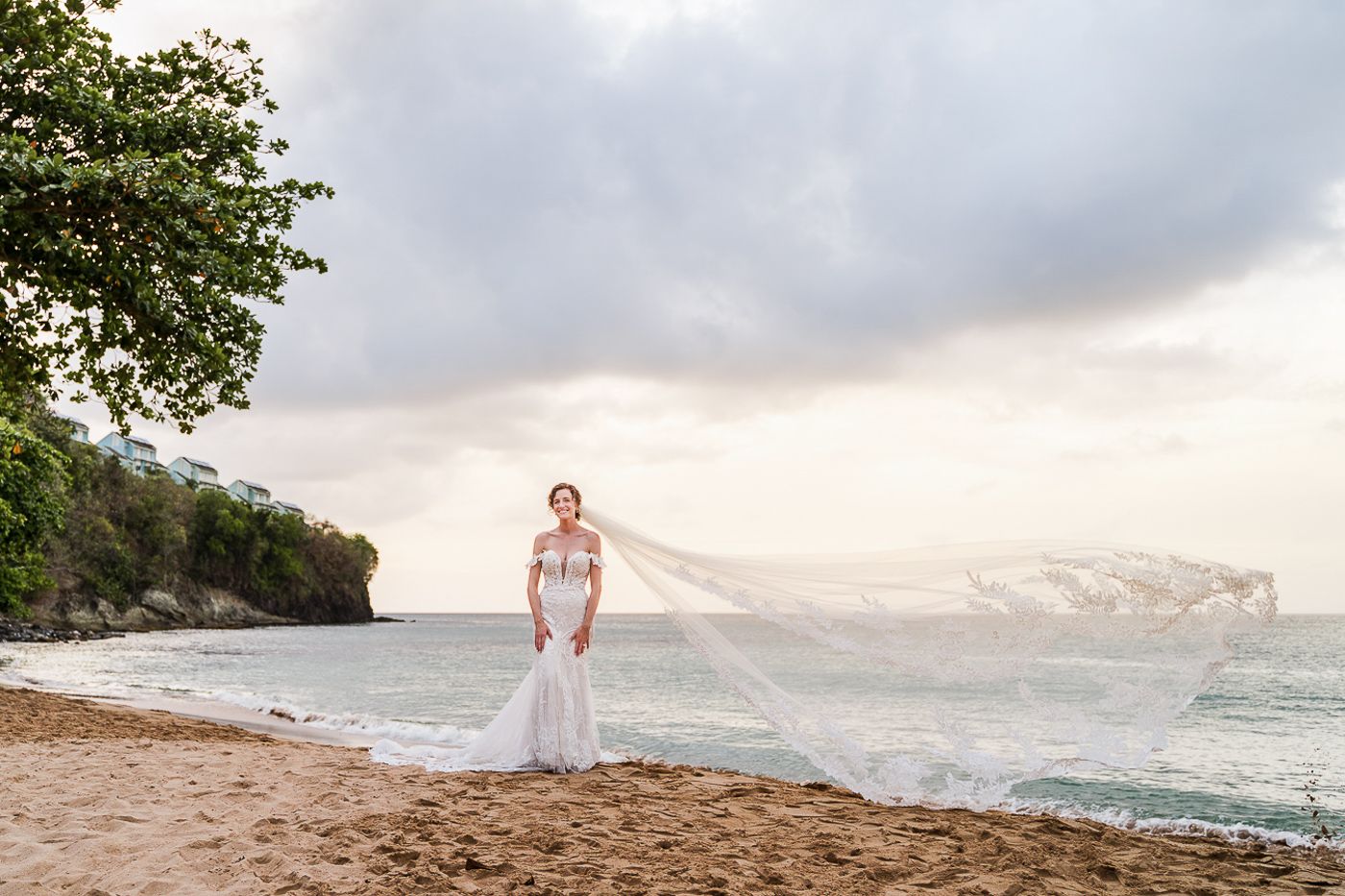 Scenic beach wedding ceremony backdrop with ocean views and palm trees at sunset.