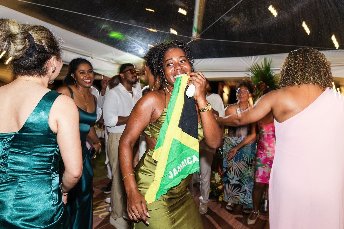 People dancing and celebrating at a party with someone wearing a bright yellow sash.