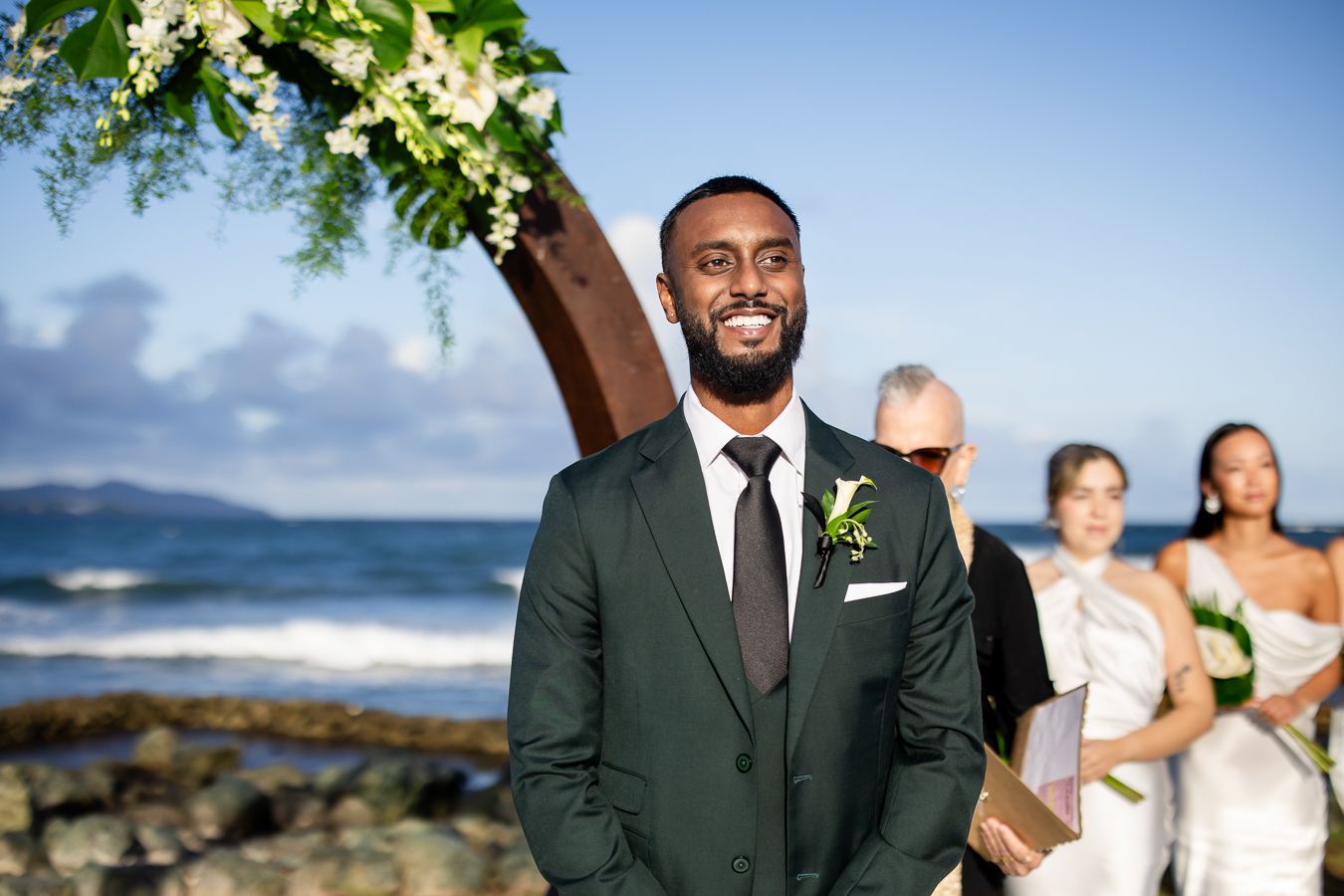 Wedding ceremony setup with tropical floral arrangements and ocean view backdrop.