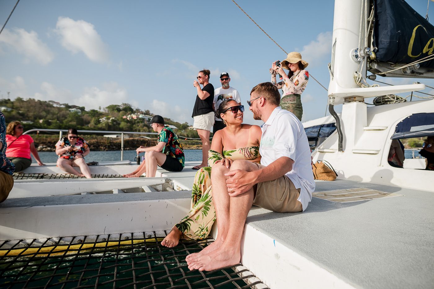 Guests enjoying a sunny day on a sailing yacht in tropical waters.