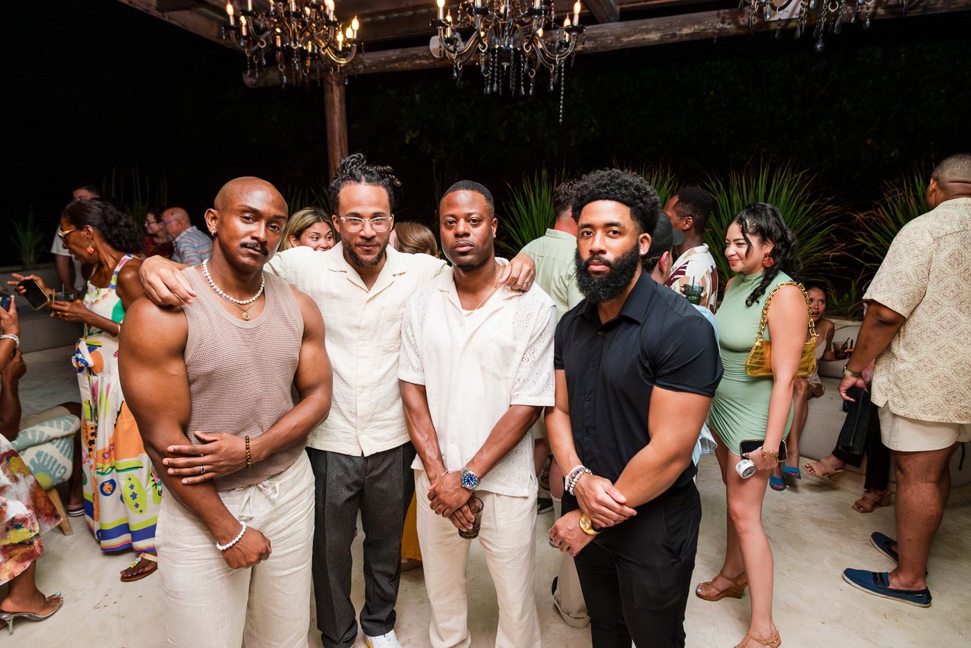Friends posing together at an evening social gathering in summer attire.
