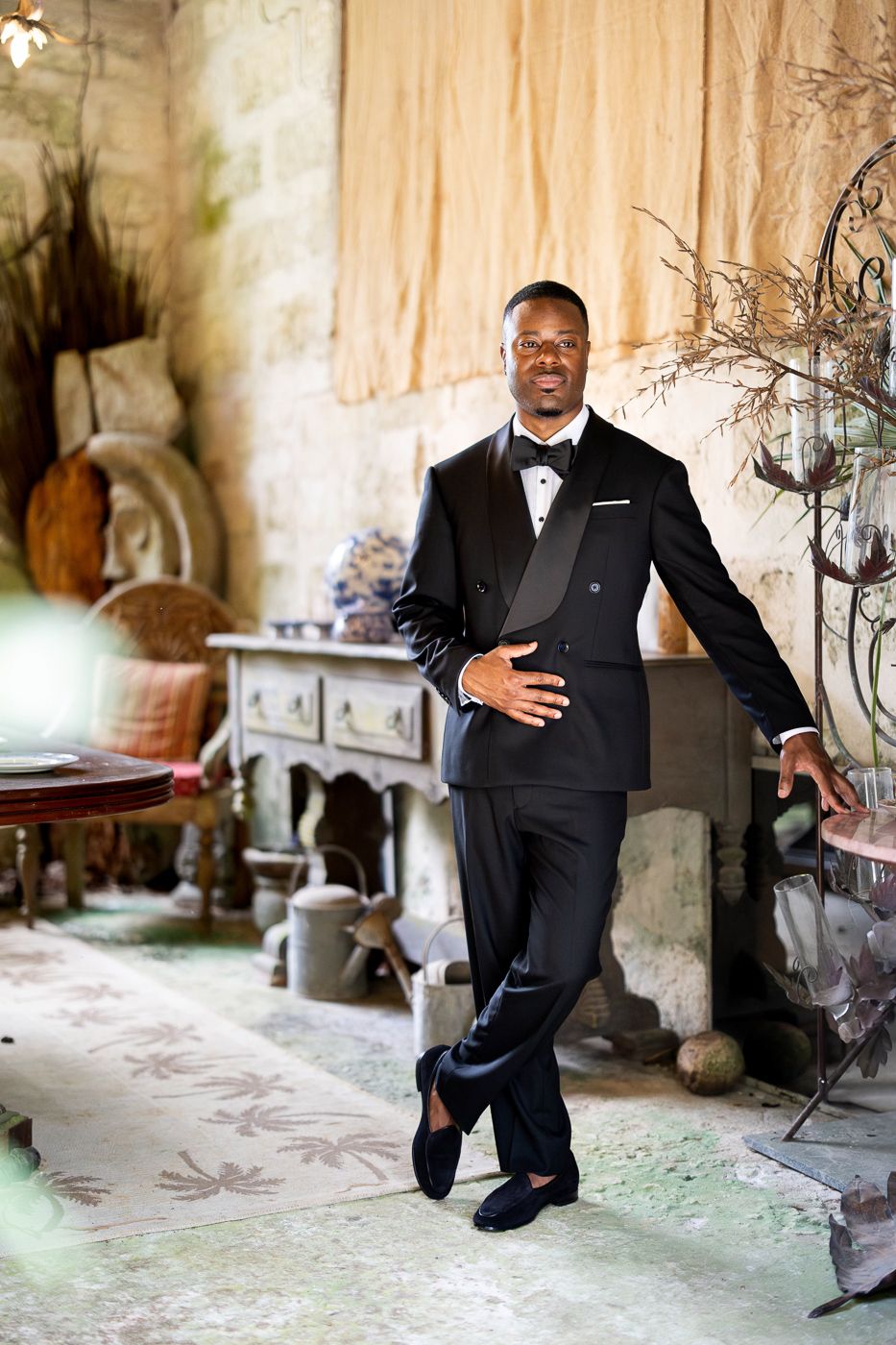 Series of stylish groom portraits showing playful poses in a rustic stone setting.