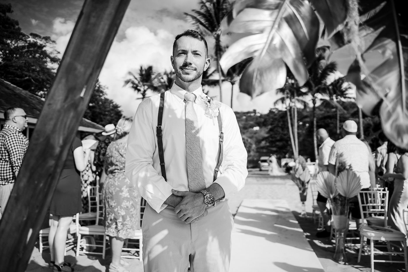 Black and white photo of guests enjoying an outdoor beach wedding ceremony in Hawaii.