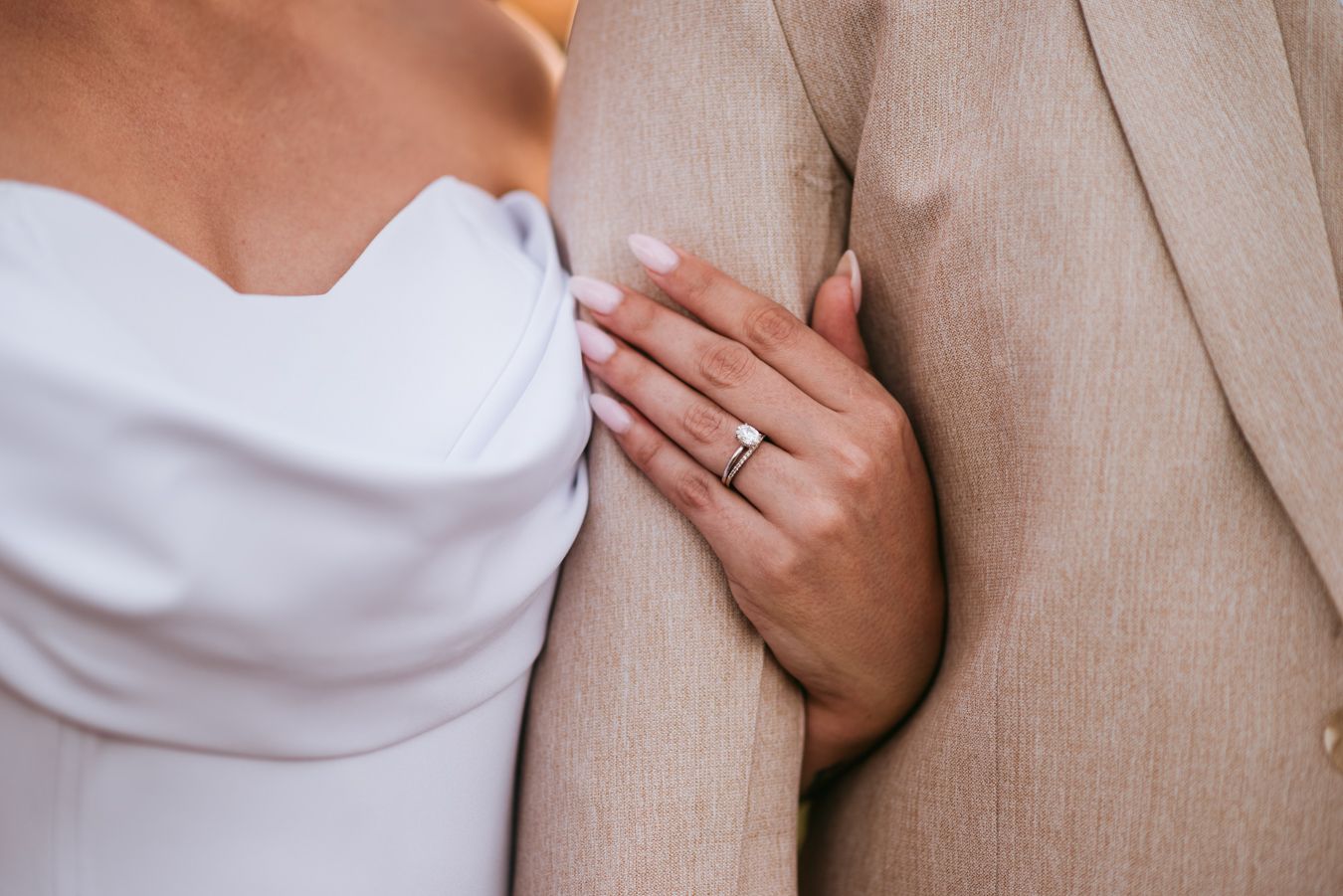 Close up view of hands gently touching a soft beige knit sweater texture.