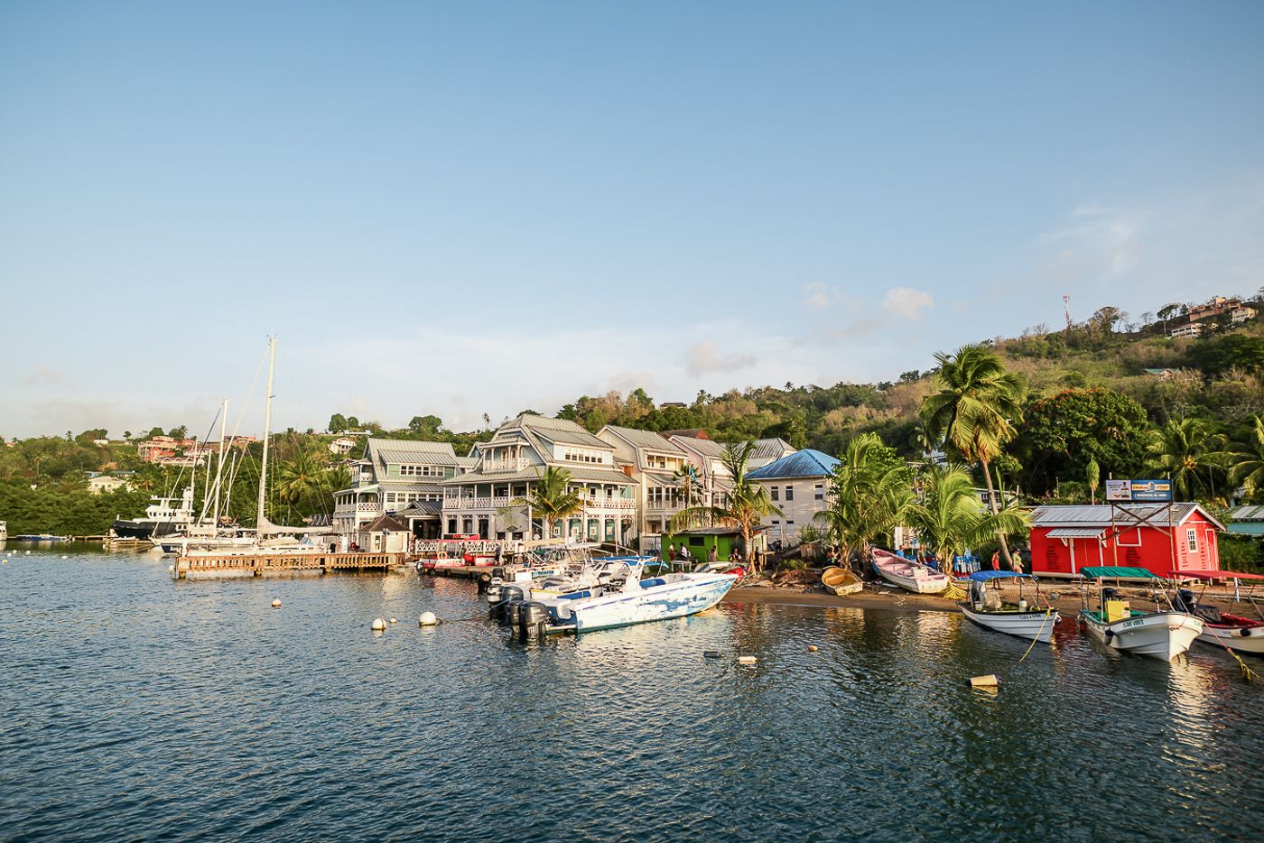 Panoramic view of a tropical marina with boats and waterfront homes.