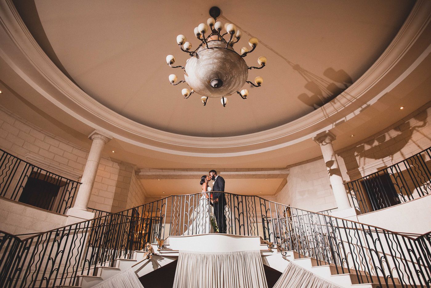 Romantic dance captured under elegant dome ceiling with dramatic lighting and architectural details.