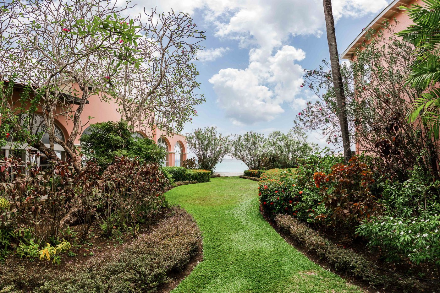 Landscaped garden pathway leading through tropical grounds at a luxury resort.