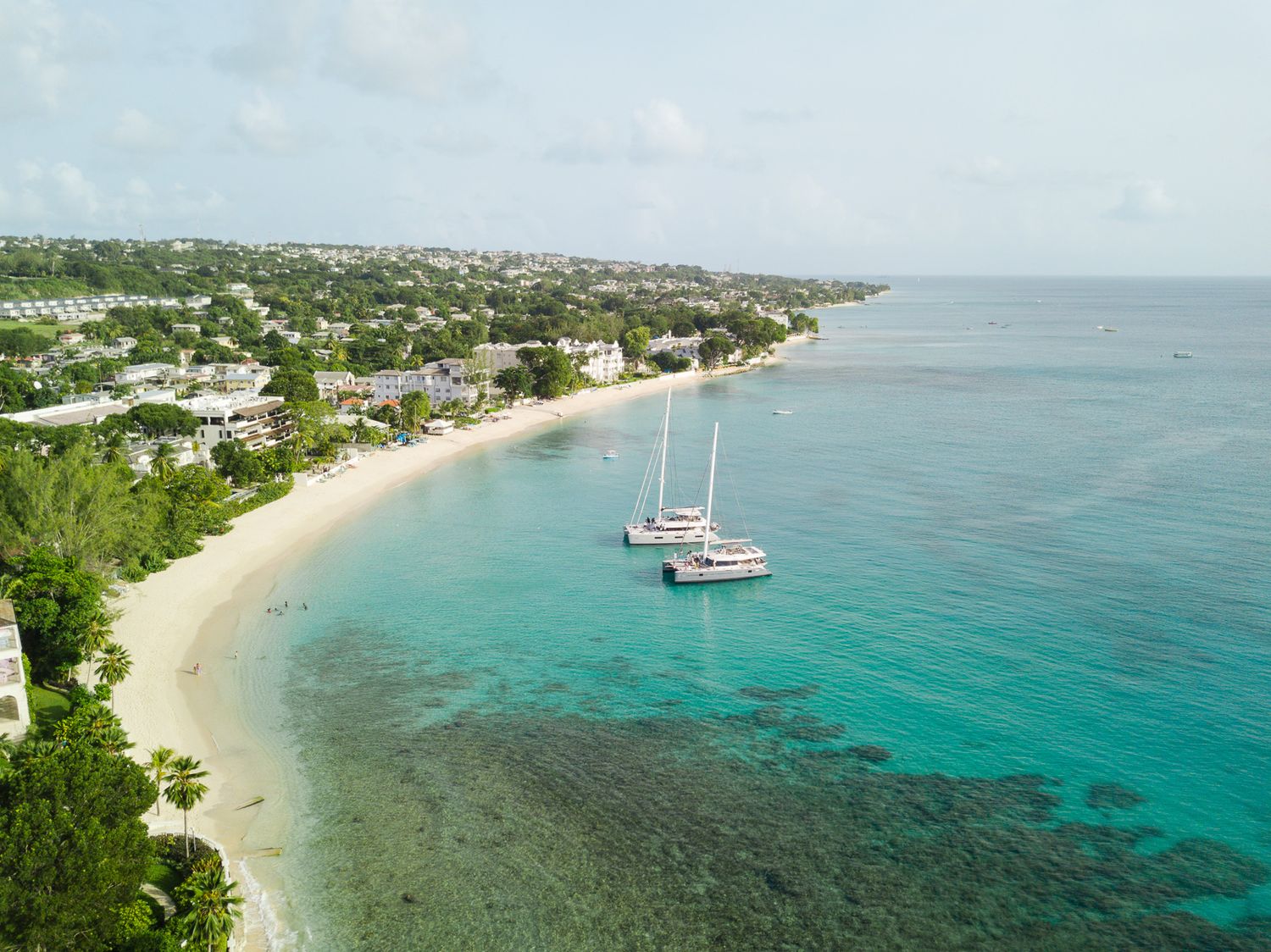 Aerial panoramic view of a tropical coastline with turquoise waters, sandy beaches and luxury boats in Barbados,  Caribbean.