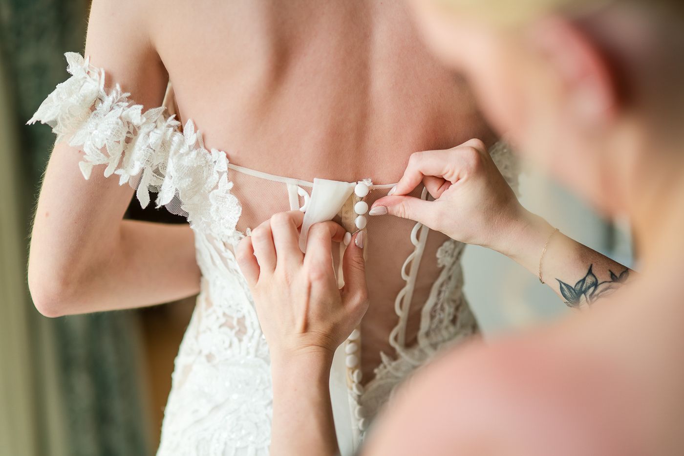 Close-up details of lace and beading on formal attire.
