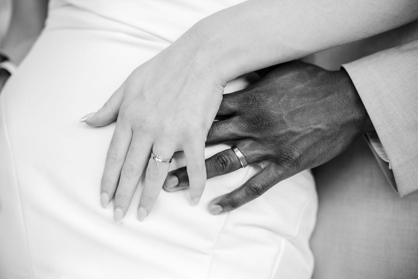 Close-up shots showing hands signing wedding documents in black and white.