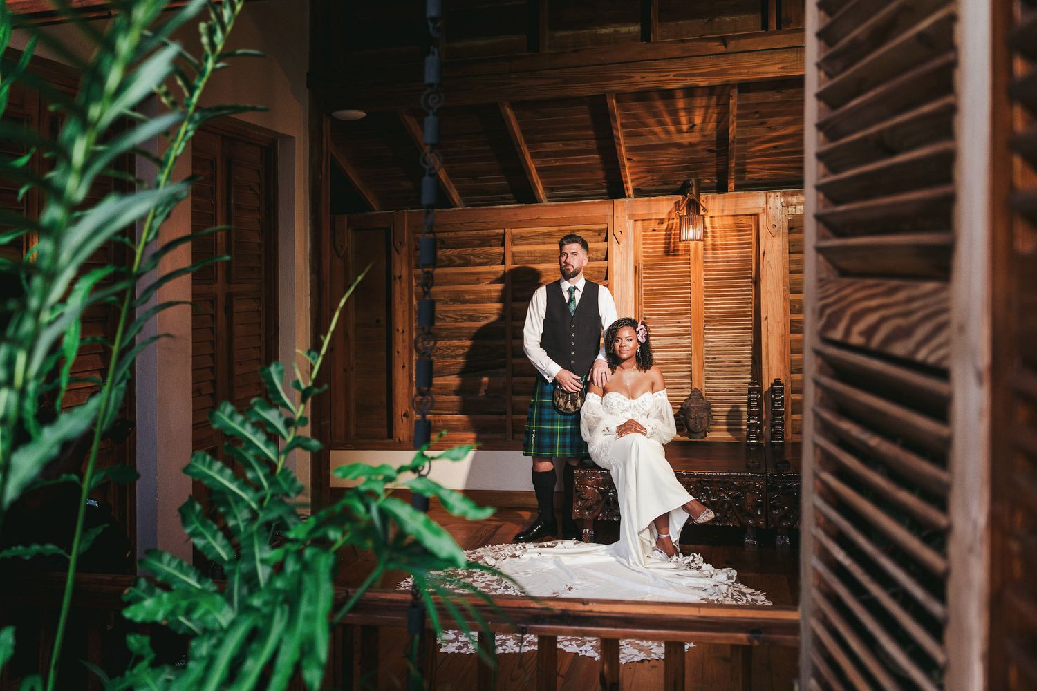 A romantic wedding photoshoot in a rustic wooden cabin setting with warm lighting and greenery.