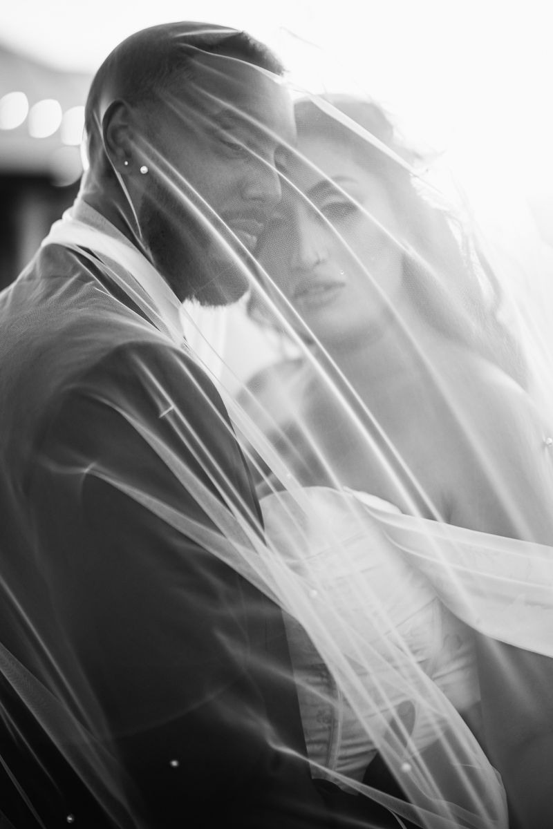 Artistic black and white close-up of flowing wedding veil in natural light.