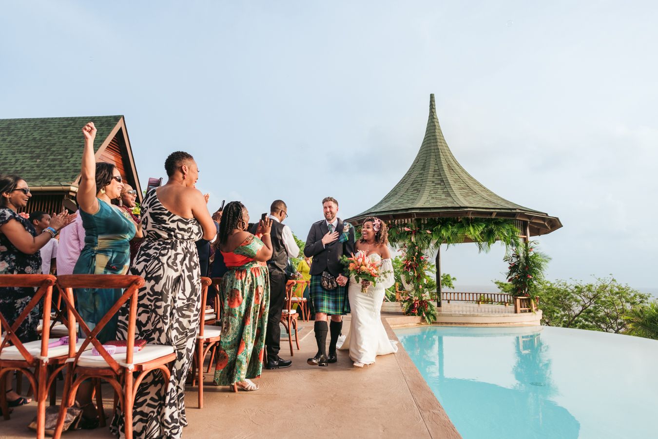 Wedding ceremony taking place at a luxurious oceanfront gazebo with infinity pool.