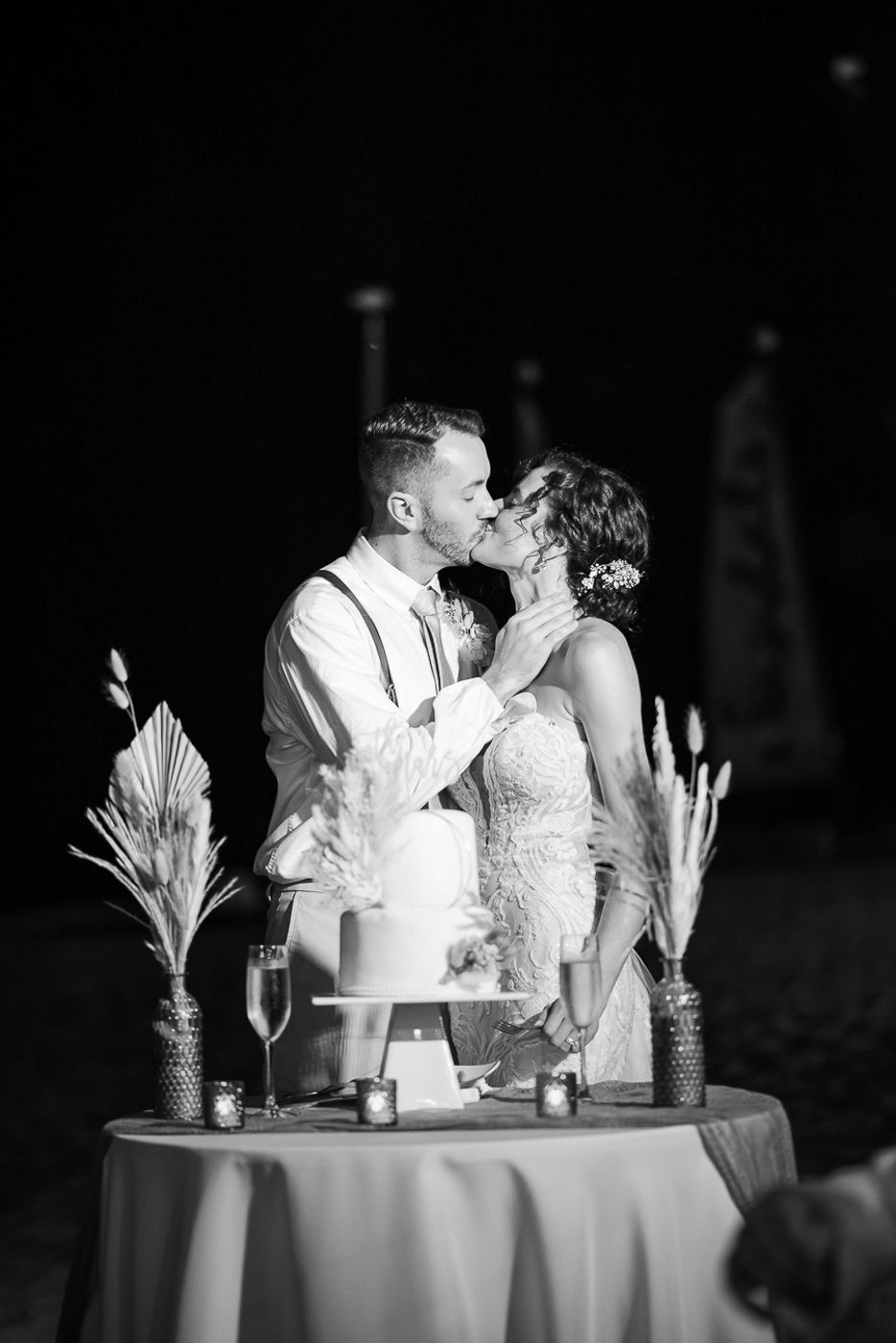 Intimate black and white photo of couple at their candlelit beach reception.