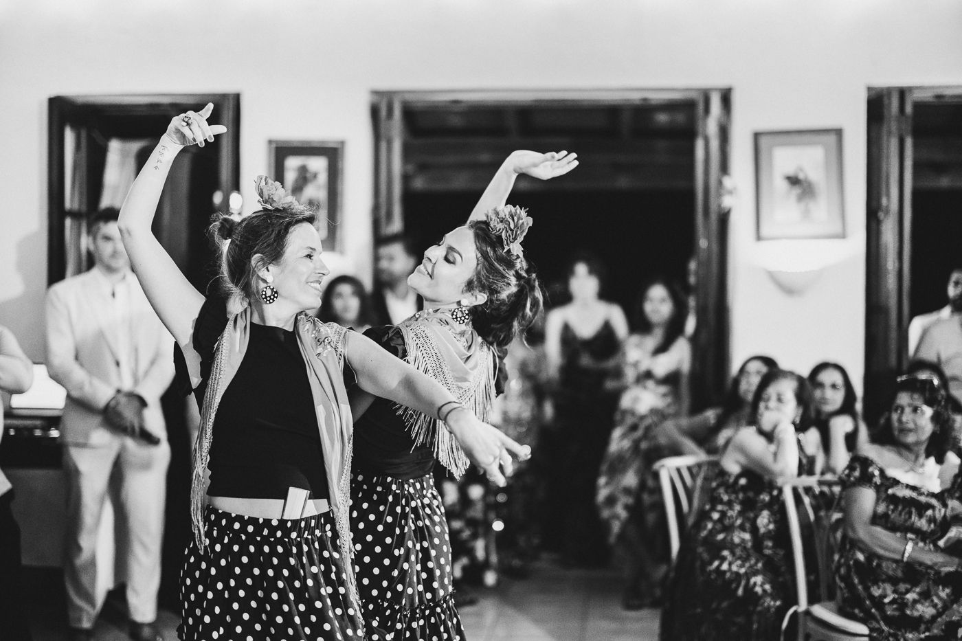 Dynamic black and white shot of dancers performing energetic moves at a celebration event.