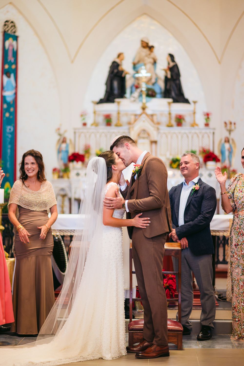 Wedding couple shares tender first dance moments in a beautiful church sanctuary decorated with glowing candles.
