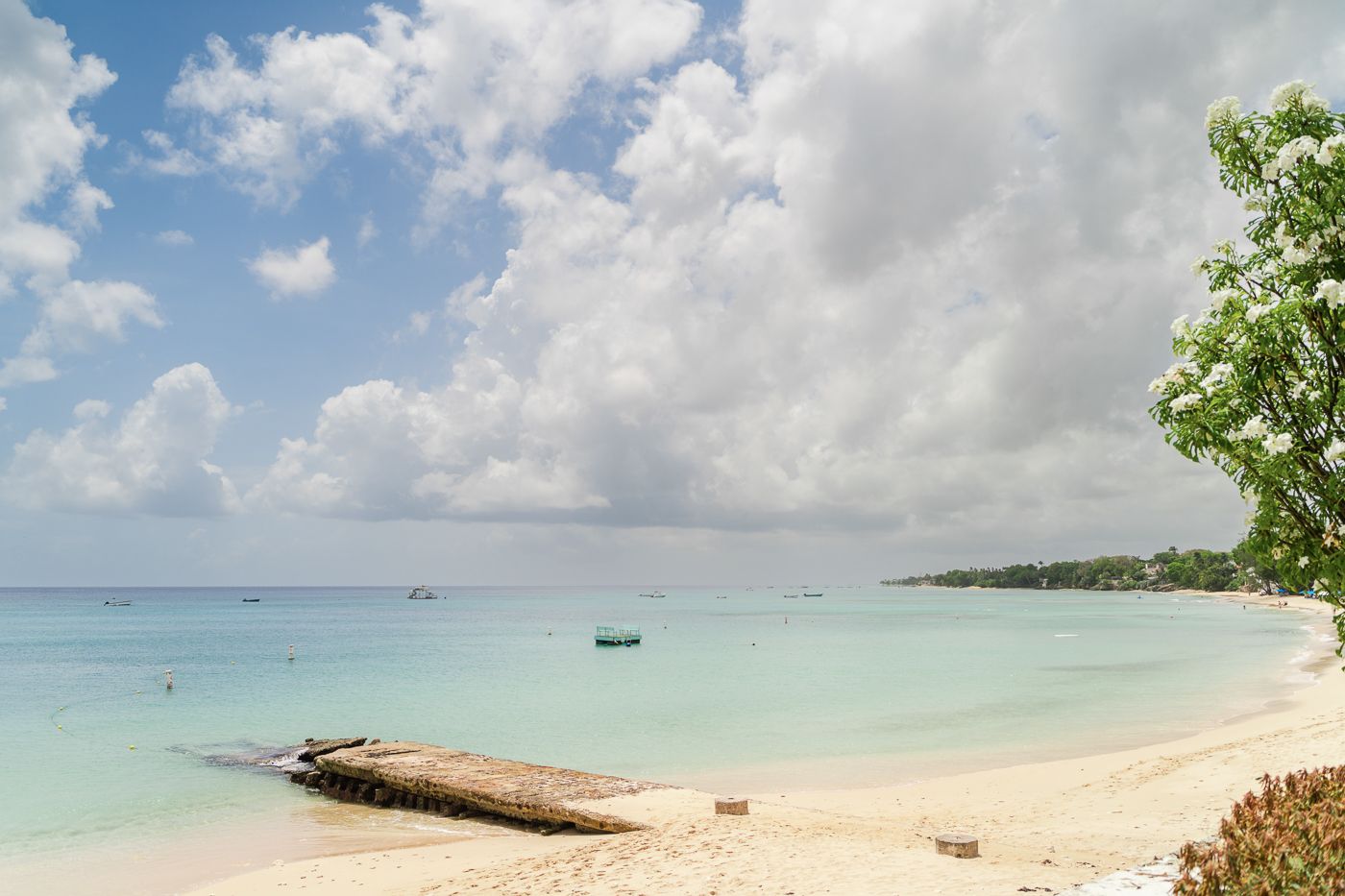 Panoramic view of a pristine Caribbean beach with turquoise waters and white sand.